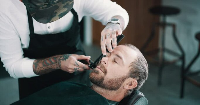 Industry, beard or shave with a barber and man in a seat as a customer for luxury or professional service. Grooming, salon or hairdresser and a person shaving the face of a client with a machine