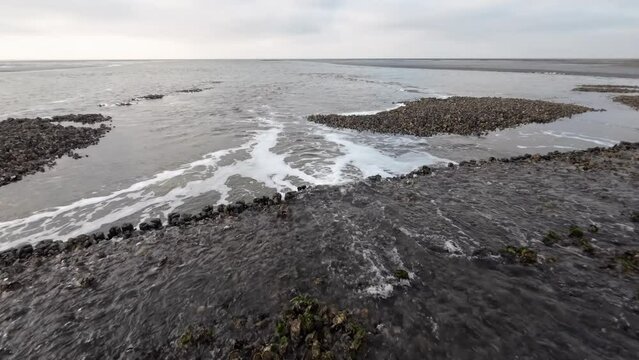 Wasserfall durch Gezeitenstr&ouml;mung im Wattenmeer mit wilden Austern- und Miesmuschelb&auml;nken, Nordsee, Schwenk
