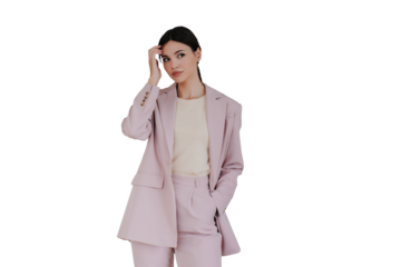 Pretty fashion model posing touching hair dressed in light pink suit standing against transparent background. Attractive asian young adult woman looking aside. Korean girl preparing to interview.