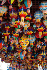 Obraz premium Different colorful souvenirs of air balloons hanging in street market. Handmade decoration and reminders for travellers in Turkey. Symbolic meaning of Cappadocia.