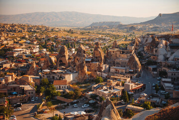 Obraz premium Top view of beautiful small town in Turkey surrounded with rocky mountains. Air Balloons flying in Cappadocia region. Concept of adventure and travelling.