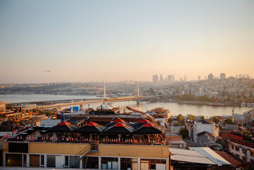 Top view of morning Istanbul with Bosphorus bridge over blue sky. Traditional building with red...
