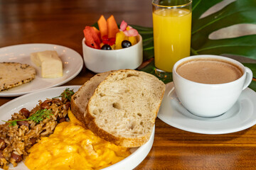 Colombian breakfast with arepas, coffee, bread, eggs, warmed rice and fruit