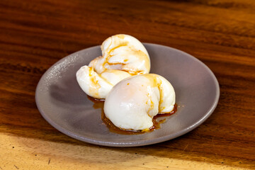 two poached eggs on a plate with olive vegetable oil