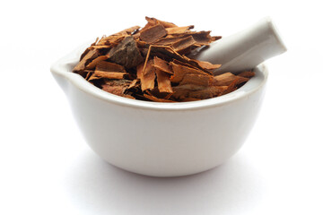 Close-up of Dry organic Cinnamon sticks (Cinnamomum verum), in white ceramic mortar and pestle,...