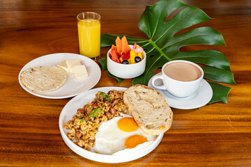 Colombian breakfast with arepas, coffee, bread, eggs, warmed rice and fruit