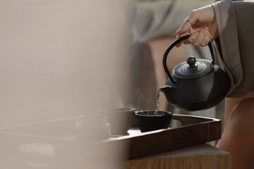 Black cast iron tea pot with herbal tea set up on wood tray. Traditional Asian Tea Set - iron...