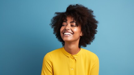 happy black woman with yellow shirt and a blue background