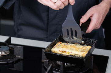 Chef man hands cooking Tamagoyaki or Tamago traditional Japanese Rolled Omelette recipe, made by...