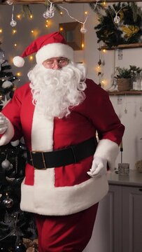 Family, children holiday, Concept. New Year traditions. Christmas Eve, Santa Claus is dancing in decorated apartment near Christmas tree with balls lights. Jolly Santa celebrates new year at home.