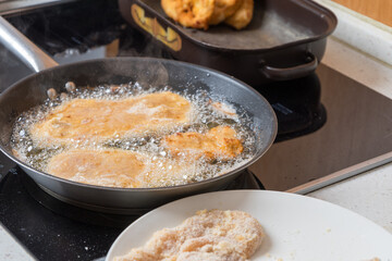 Wrapped chicken cutlets for frying in a pan in oil.
