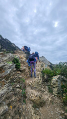 Fototapeta premium Zambujeira do Mar over the sea shore with ocean waves, cliffs and sand dunes covered by green vegetation red leaves of sour fig, sunny day, clear blue sky. Rota Vicentina coast, Portugal.