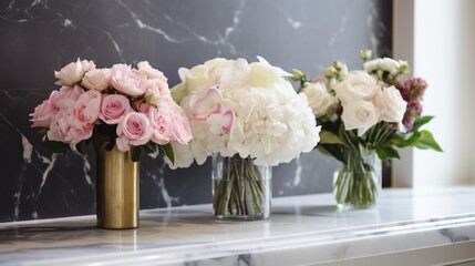  three vases filled with pink and white flowers on top of a white marbled counter in front of a black wall and a black marbled - stone wall.