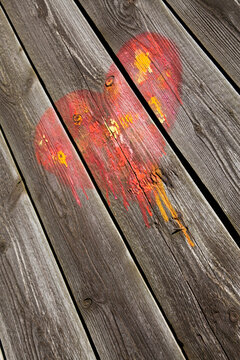 Gespr&uuml;htes Herz in rot und orange auf Holz / Streetart
