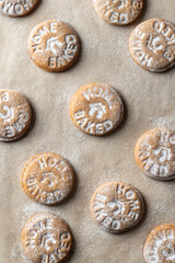 Homemade gingerbread cookies on parchment background Top view. Christmas traditional desserts concept, pattern
