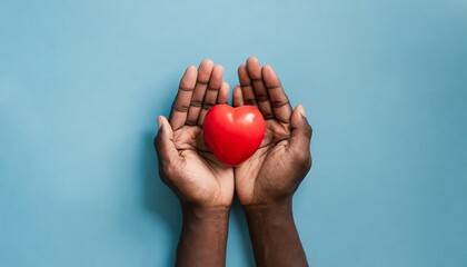 top view of hands holding red heart in concept healthcare wellbeing organ donation and insurance life world heart day world health day national organ donor day on a blue background