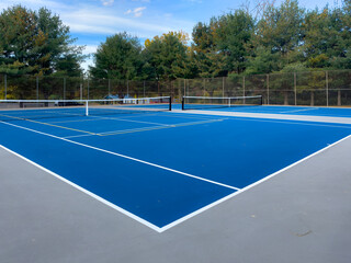 Close up photo of a outdoor blue tennis court with white lines combined with yellow, gold,...
