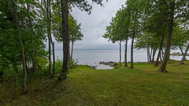 Fishing time lapse at Lake Manitou during rain, Ontario, Canada. Angler throwing rod line into the water. Fly fishing. Family leisure on the wild lake. Reel fishing. Summer hobby and vacation.