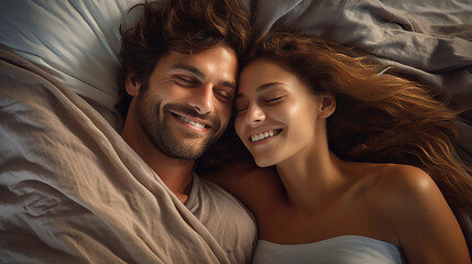 Fototapeta na wymiar Image of a young couple smiling and cuddling on comfortable bedding.