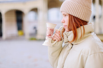 Young girl drinking from cup with therapeutic mineral water at a natural hot spring in Karlovy Vary 