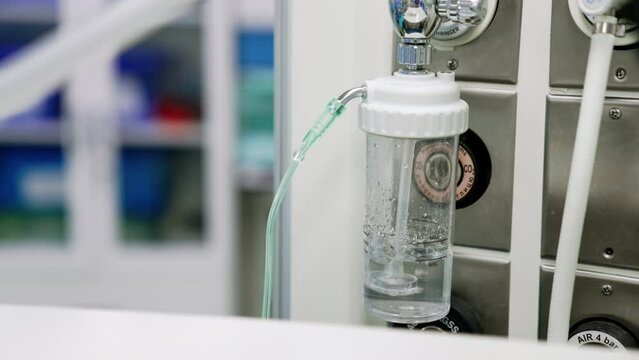 Flowmeter device with water bubbling inside. Equipment regulating the speed of oxygen flow for patients. Close up.