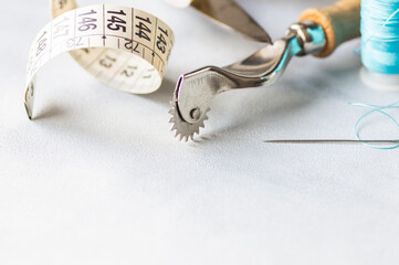 Tailor sewing accessories, craft concept background, scissors, tracing wheel, measure, threads