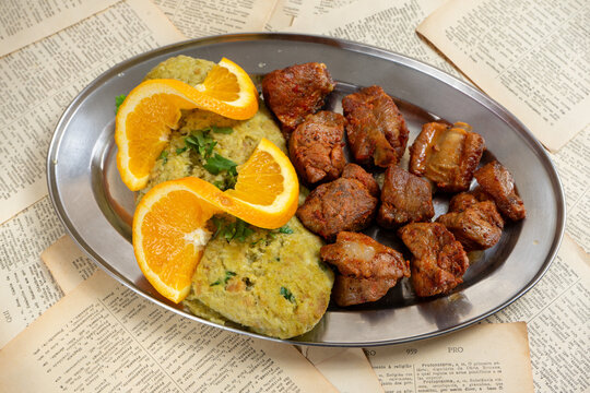 Fried pork with asparagus migas served at a restaurant, a delightful Portuguese culinary delight.