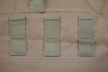 green brown texture of fabric from a part of a backpack with sewn stripes