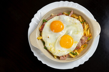 Broken eggs: a Spanish dish of fried eggs on a bed of crispy potatoes and ham, a flavorful and comforting delicacy.