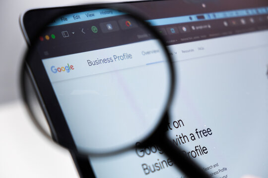 Google Business Profile logo on the screen of laptop through magnifying glass, December 2023, Prague, Czech Republic