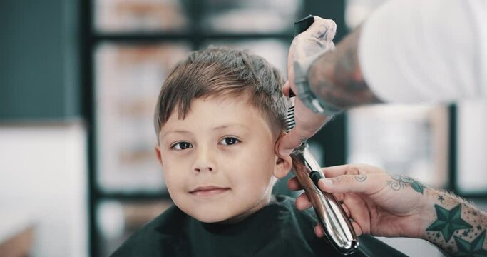 Hair care, portrait and kid in barbershop with machine, clipper and tools for trendy hairstyle at small business. Style, barber and boy in chair for grooming service, creative haircut or happy trim.