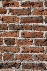 Alte Backsteinwand - verwitterte Backsteine einer Fassade - dunkelrote Backsteinfassade