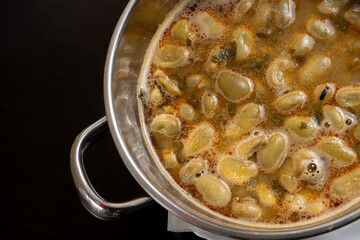 Traditional Portuguese dish of favas with chouriço, served in a rustic restaurant setting.