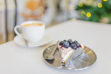 blueberies cheese cake on stainless dish, bakery and hot coffee in cafe