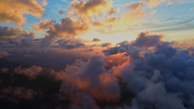 Cloudy sky landscape at sunset with orange sunlight, aerial view from drone.