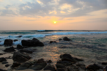 The sun setting into the sea at Delawella beach, Sri Lanka. Golden light