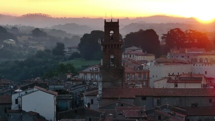 Pitigliano veduta dall'alto del campanile della cattedrale sullo sfondo il borgo medievale e le colline all'alba