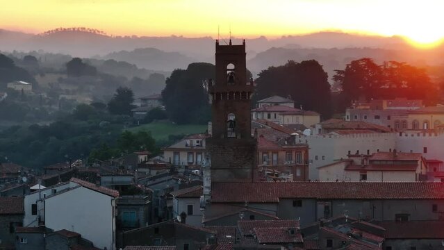 Pitigliano veduta dall'alto del campanile della cattedrale sullo sfondo il borgo medievale e le colline all'alba