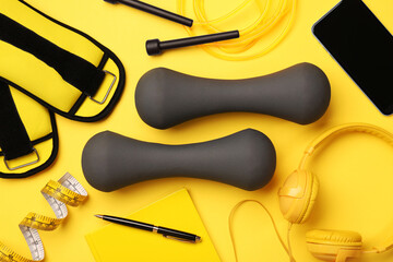 Flat lay composition with dumbbells on yellow background