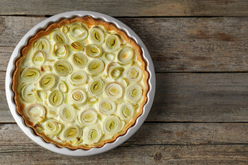 Tasty leek pie on old wooden table, top view. Space for text