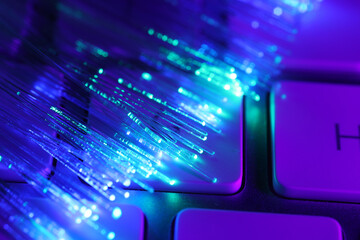 Optical fiber strands transmitting different color lights on computer keyboard, macro view