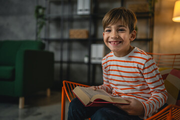 Fototapeta na wymiar One caucasian boy child at home read a book education concept