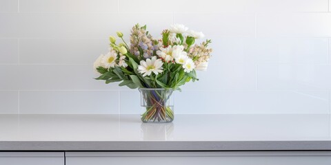 White kitchen bench adorned with flowers and splashback