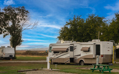 Rv motorhome and camper parked at campsite on grass