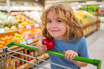 Child with grocery basket shopping at supermarket. Grocery store, shopping basket. Banner with kids for grocery food store or supermarket. Child choosing food in store or grocery store.