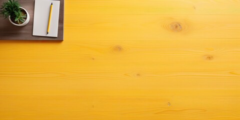 Top-down view of a wooden table with yellow files and space for text.