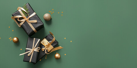 Christmas gift boxes and baubles on green background with space for text, top view