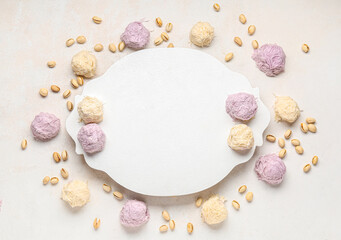 Board with tasty Turkish Pismaniye and nuts on white background