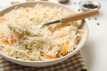 Bowl with delicious sauerkraut on white background