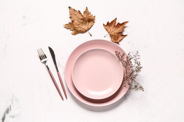 Stylish autumn table setting with dry maple leaves and dried flowers on white background